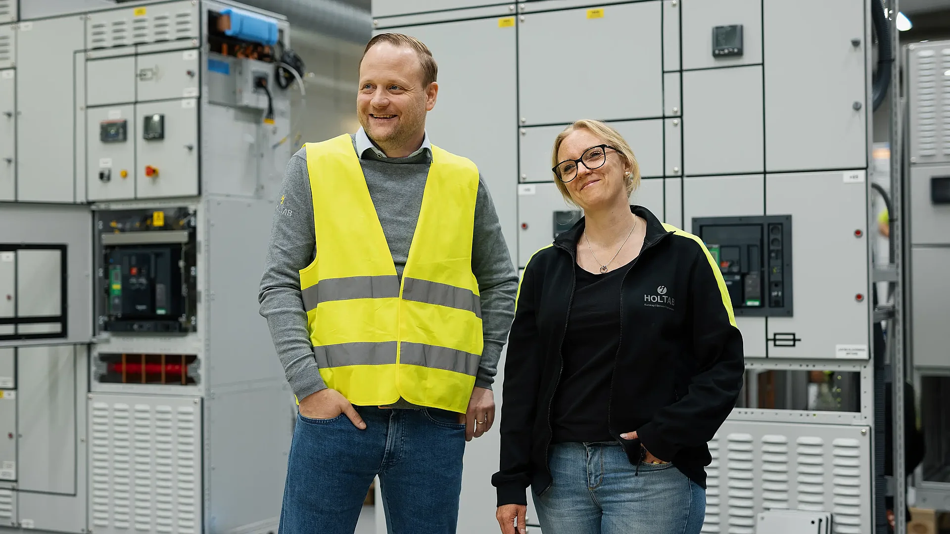 Man and a woman in front a low voltage switchboard